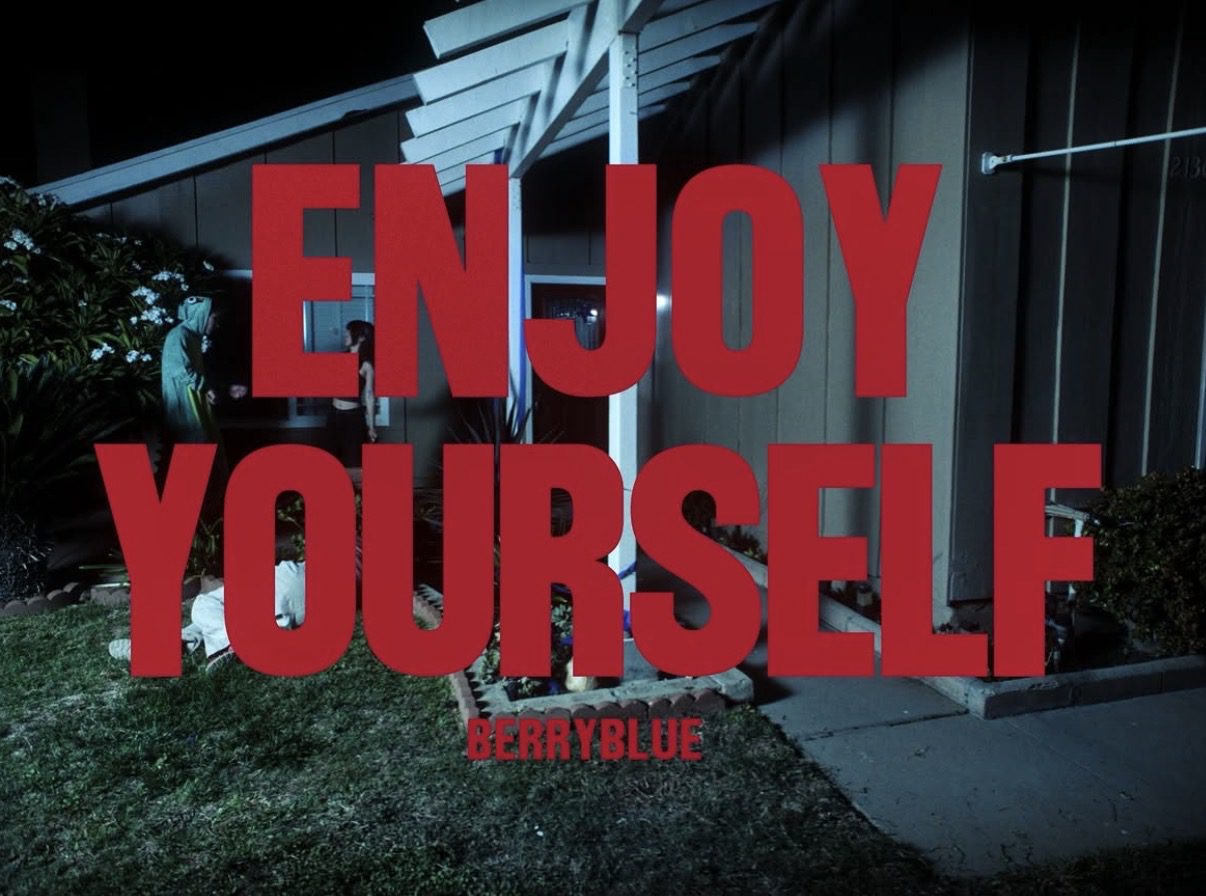 Red "Enjoy Yourself" text over suburban house