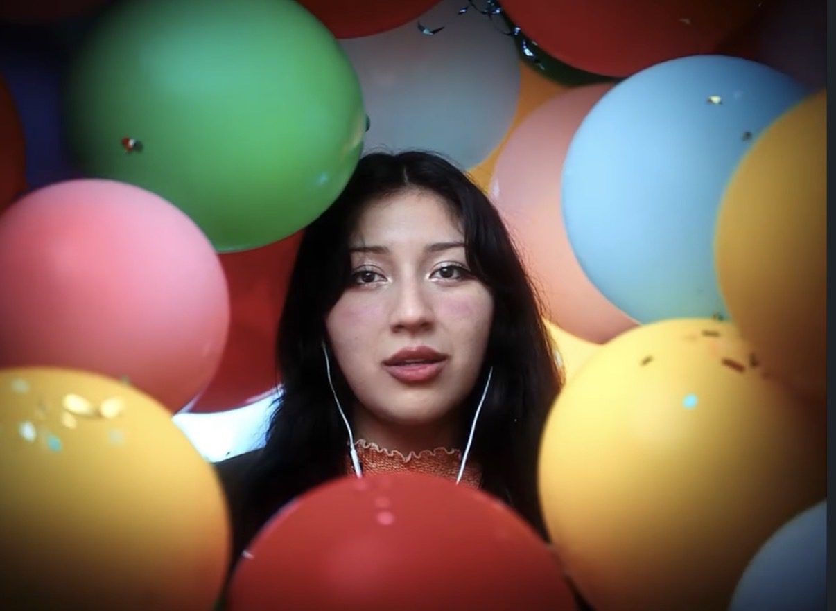 Young woman surrounded by colorful balloons